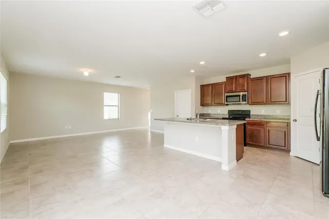 a kitchen with a refrigerator and a stove top oven