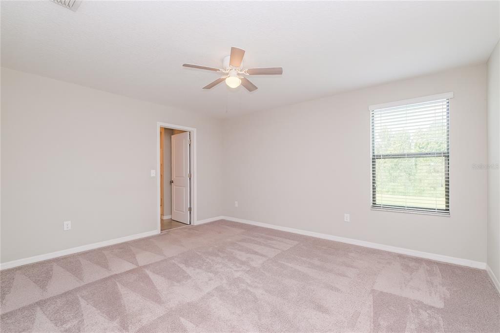 36125 Stable Wilk Avenue Zephyrhills, FL 33541 - Photo 6 of 17 an empty room with windows and fan