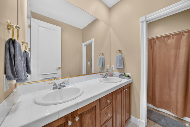 767 Draper View Road Draper, UT 84020 - Photo 32 of 71 Bathroom featuring a dual-sink vanity with white tile countertop and wood cabinetry