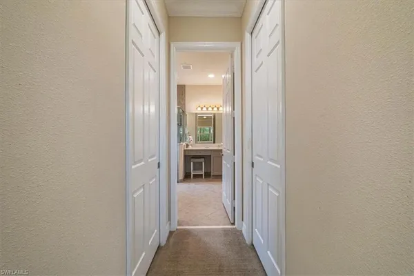 a view of a hallway with wooden floor and a bathroom