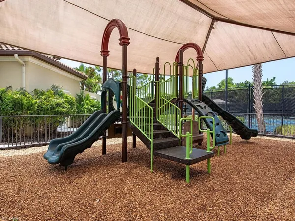 a park with a slide and wooden fence