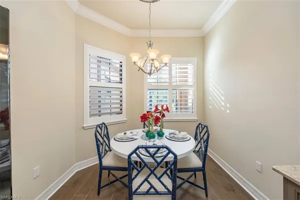 a view of a dining room with furniture a chandelier and wooden floor