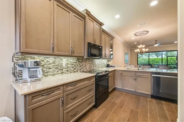 a kitchen with stainless steel appliances granite countertop a sink and dishwasher a stove top oven with wooden floor