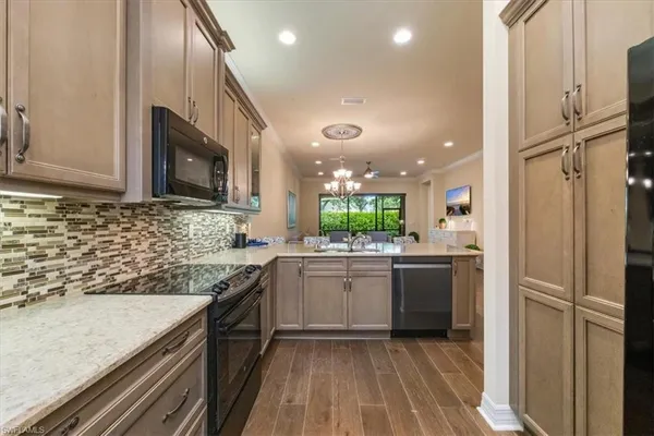 a kitchen with kitchen island granite countertop appliances cabinets and a sink