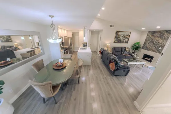 a view of a dining room and livingroom with furniture wooden floor and a chandelier