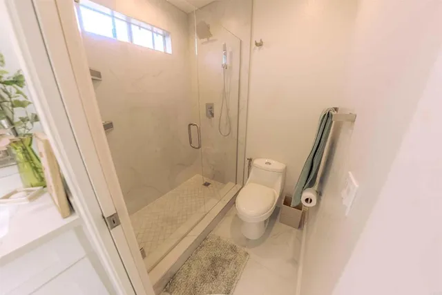 a bathroom with a granite countertop sink toilet and shower