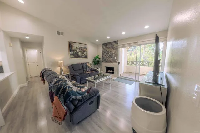 a living room with furniture potted plant and a flat screen tv