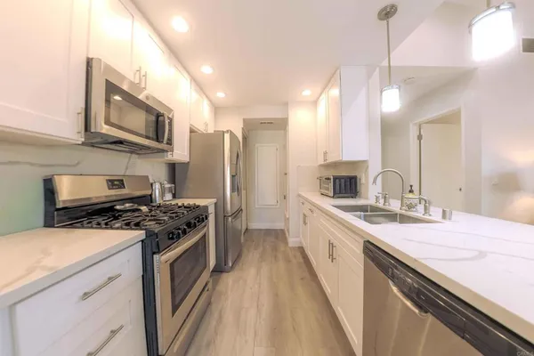 a open kitchen with kitchen island a sink stainless steel appliances and cabinets
