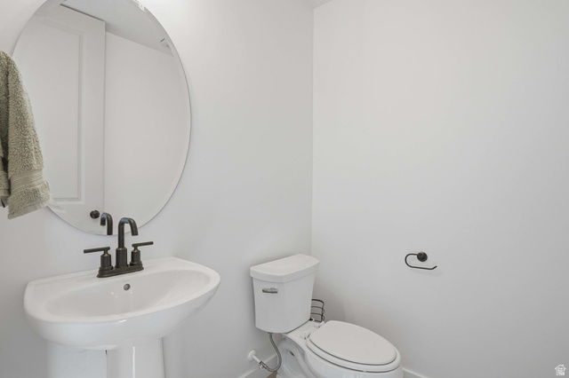 11531 Engelmann Drive Draper, UT 84020 - Photo 12 of 31 Pedestal sink with matte black hardware, oval mirror, and white toilet