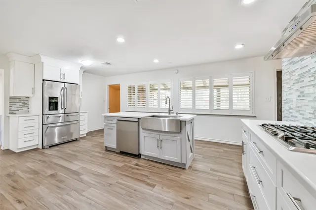 a kitchen with granite countertop a sink cabinets and stainless steel appliances