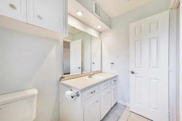 a bathroom with a sink a toilet and a mirror