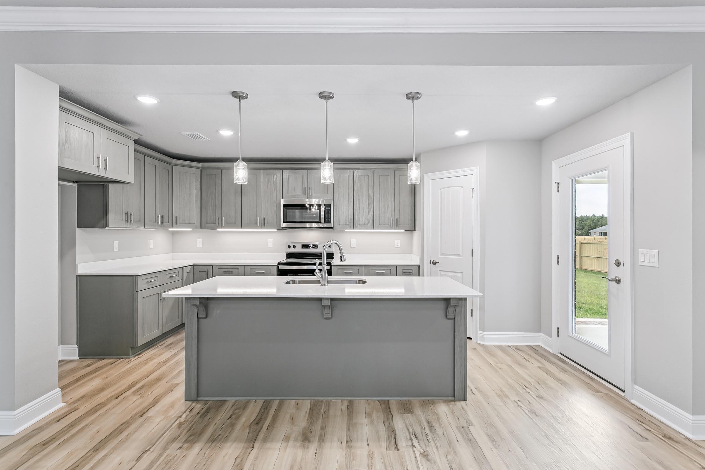 4823 Horace Lunsford Road Milton, FL 32570 - Photo 11 of 34 a kitchen with stainless steel appliances granite countertop a stove a refrigerator a sink dishwasher and a oven with wooden floor