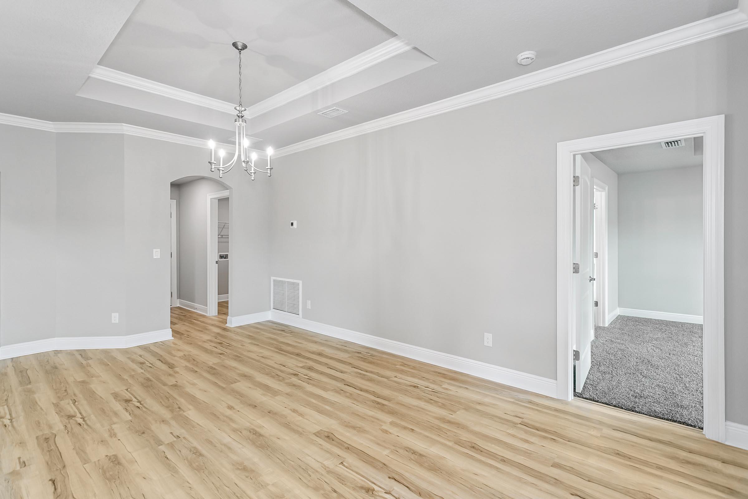 4823 Horace Lunsford Road Milton, FL 32570 - Photo 9 of 34 en empty room with wooden floor and chandelier