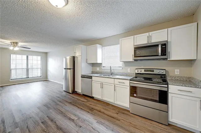 a kitchen with stainless steel appliances granite countertop a stove a sink and a microwave