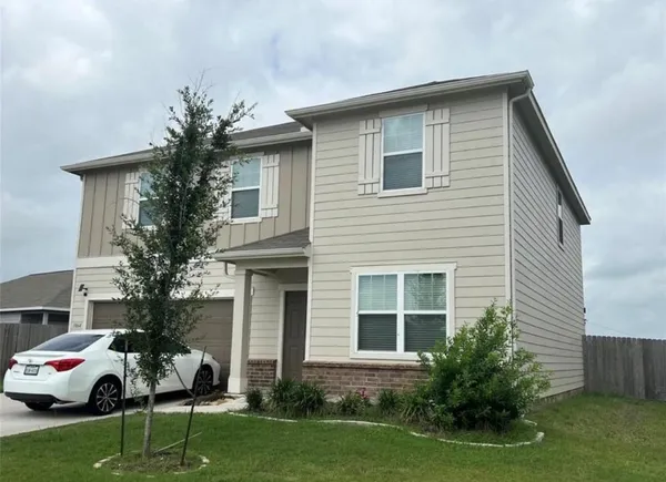 a front view of a house with a garden and yard