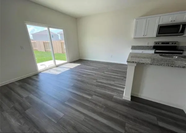 an empty room with wooden floor and a window