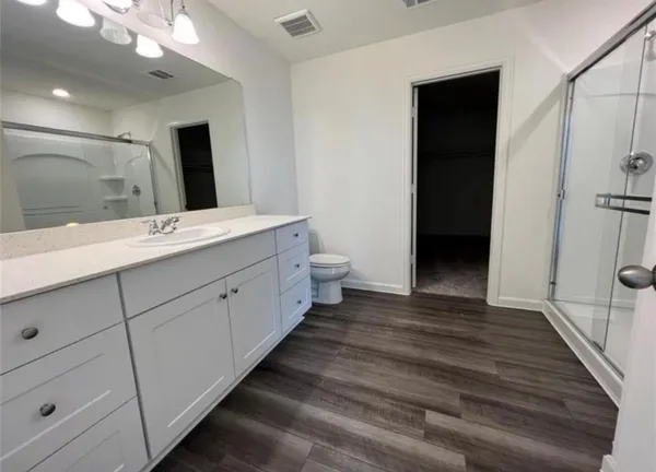 a spacious bathroom with a double vanity sink a large mirror and shower