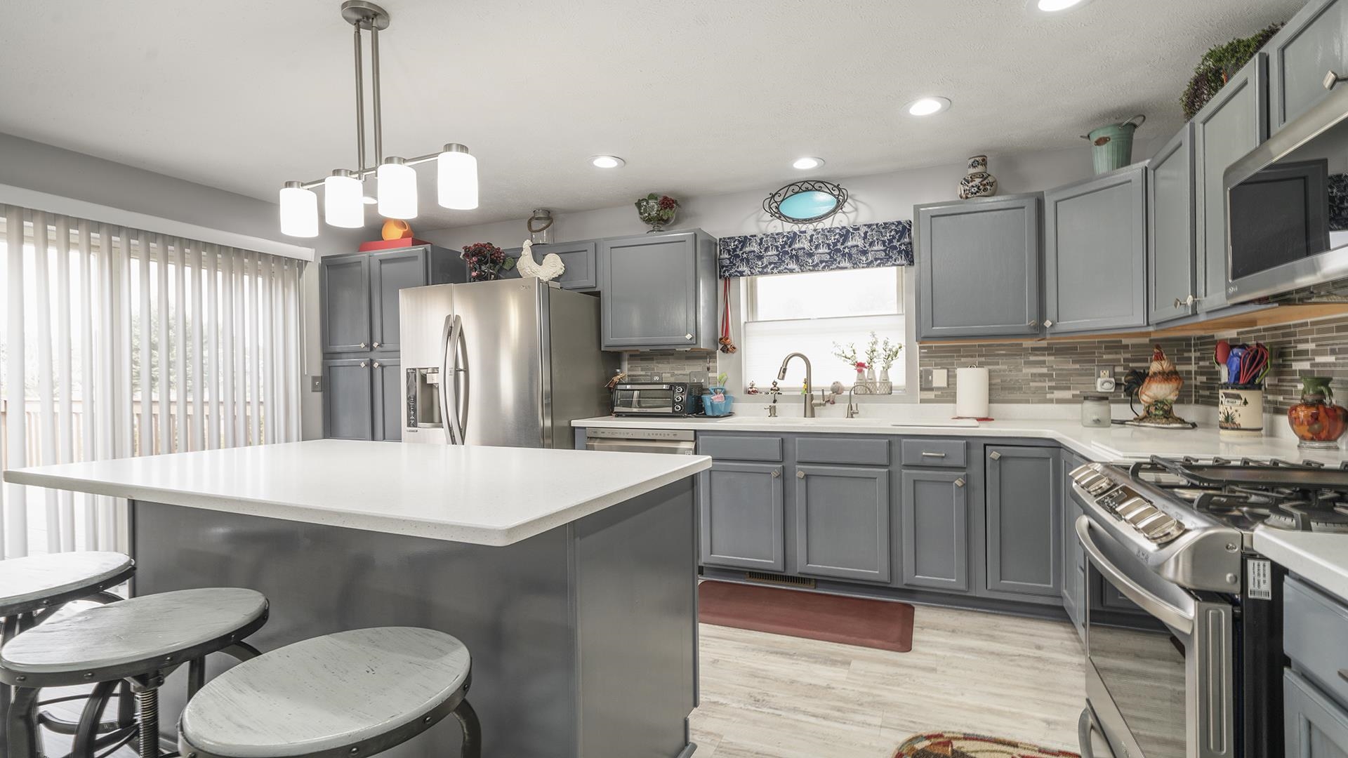 501 Pembroke Road Southwest Poplar Grove, IL 61065 - Photo 3 of 40 a kitchen with stainless steel appliances granite countertop a sink a stove a refrigerator cabinets and a dining table
