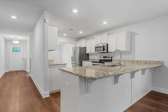 a kitchen with stainless steel appliances granite countertop a sink stove and refrigerator