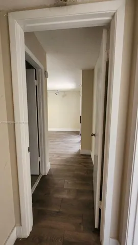 a view of a hallway with wooden floor and closet