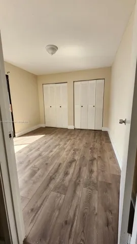 an empty room with wooden floor and white walls