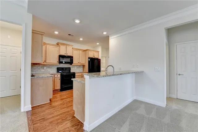 a kitchen with stainless steel appliances granite countertop wooden cabinets a stove a sink and a microwave