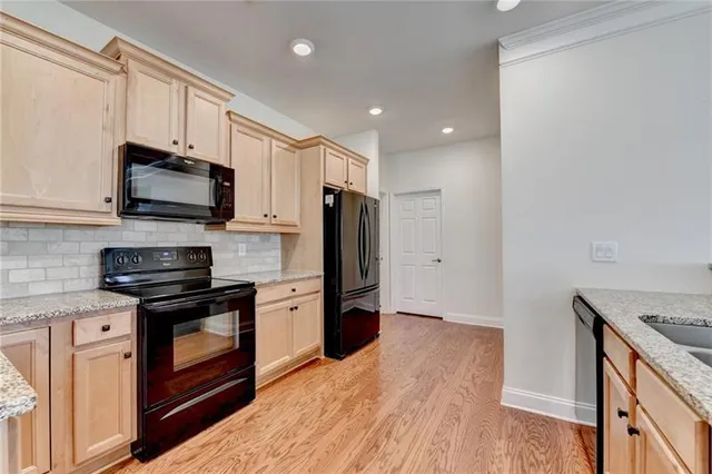 a kitchen with granite countertop white cabinets sink and stainless steel appliances