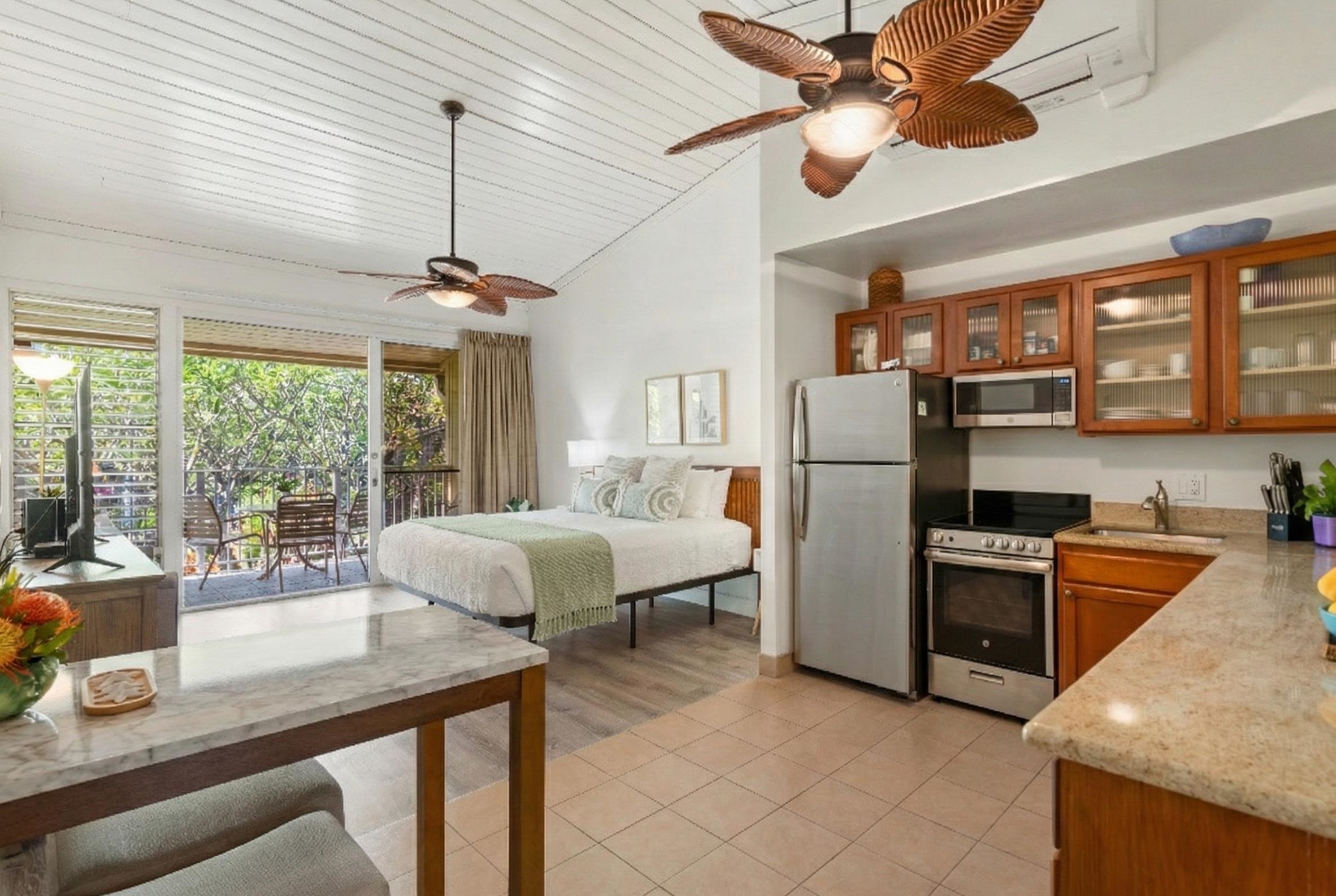 5315 Lower Honoapiilani Road, Unit D232 Lahaina, HI 96761 - Photo 10 of 31 a kitchen with stainless steel appliances granite countertop a refrigerator a sink dishwasher a stove and white countertops with wooden floor