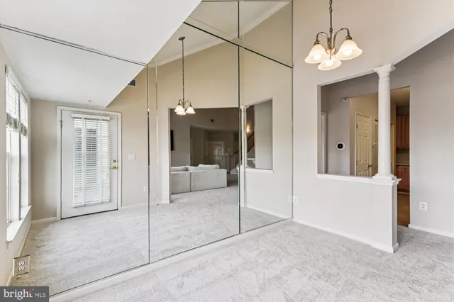 a view of a hallway with a chandelier fan and windows
