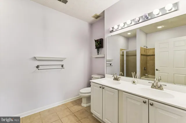 a bathroom with a double vanity sink a toilet and a mirror