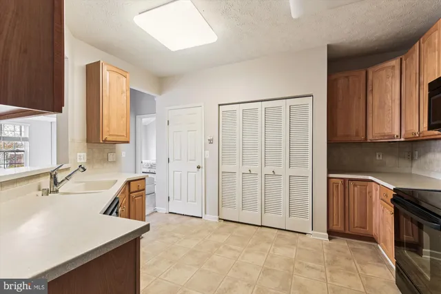 a kitchen with stainless steel appliances granite countertop a sink and a refrigerator