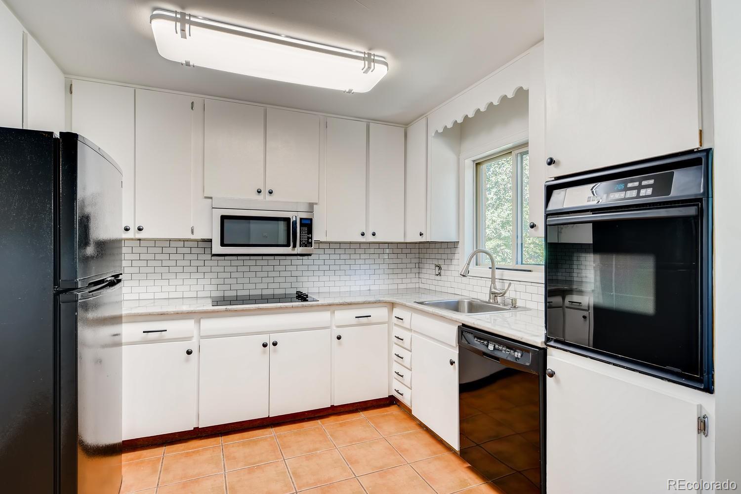 6644 South Race Circle East Centennial, CO 80121 - Photo 4 of 20 a kitchen with granite countertop white cabinets and stainless steel appliances
