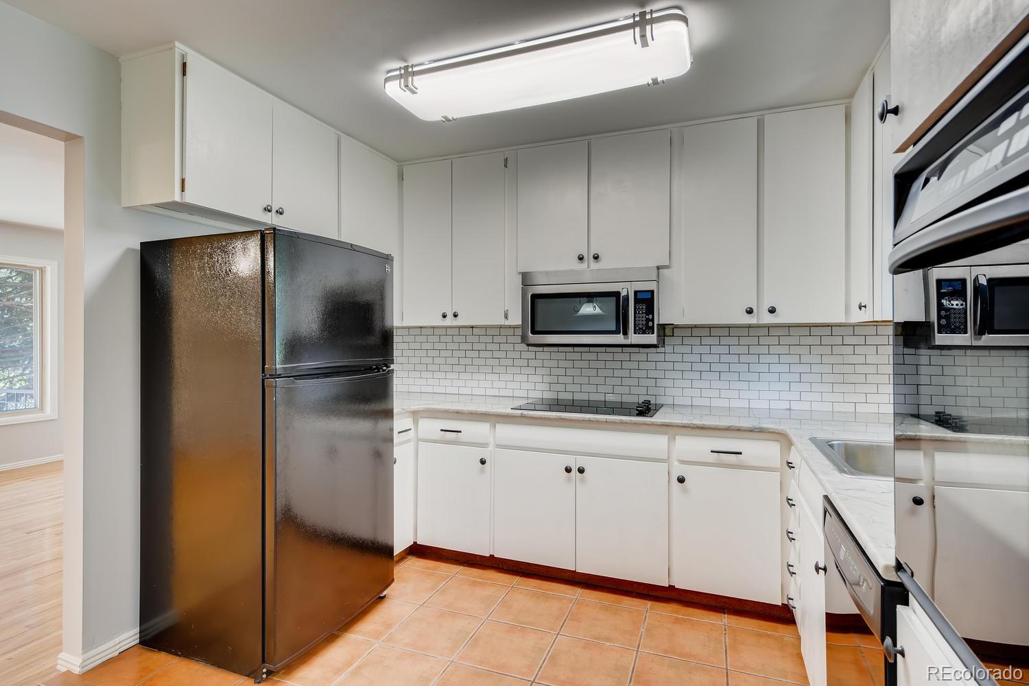6644 South Race Circle East Centennial, CO 80121 - Photo 5 of 20 a kitchen with stainless steel appliances granite countertop a refrigerator a sink and white cabinets