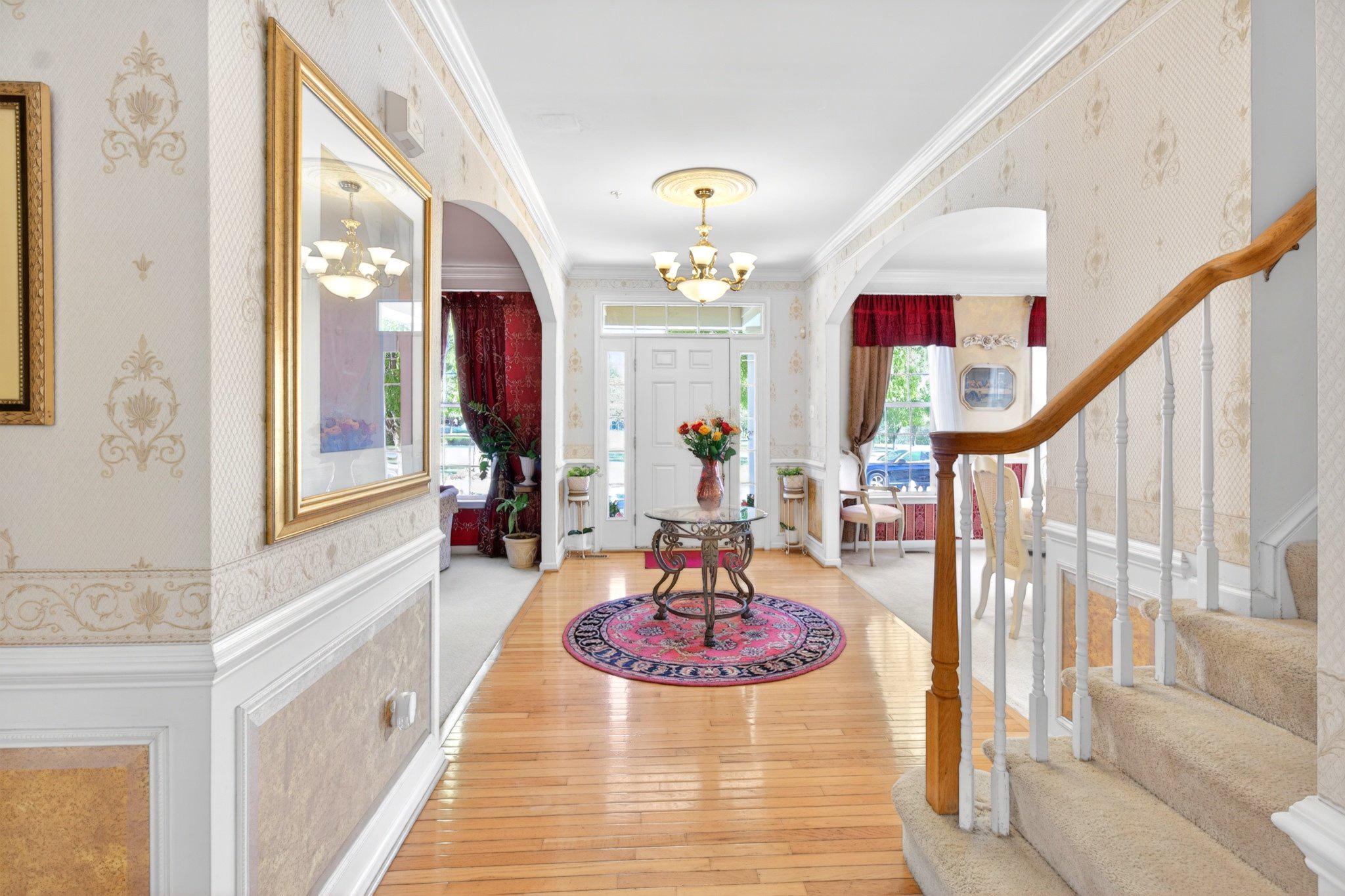 14305 Lightfoot Street Accokeek, MD 20607 - Photo 19 of 66 a view of a hallway with a dining table couches and chandelier