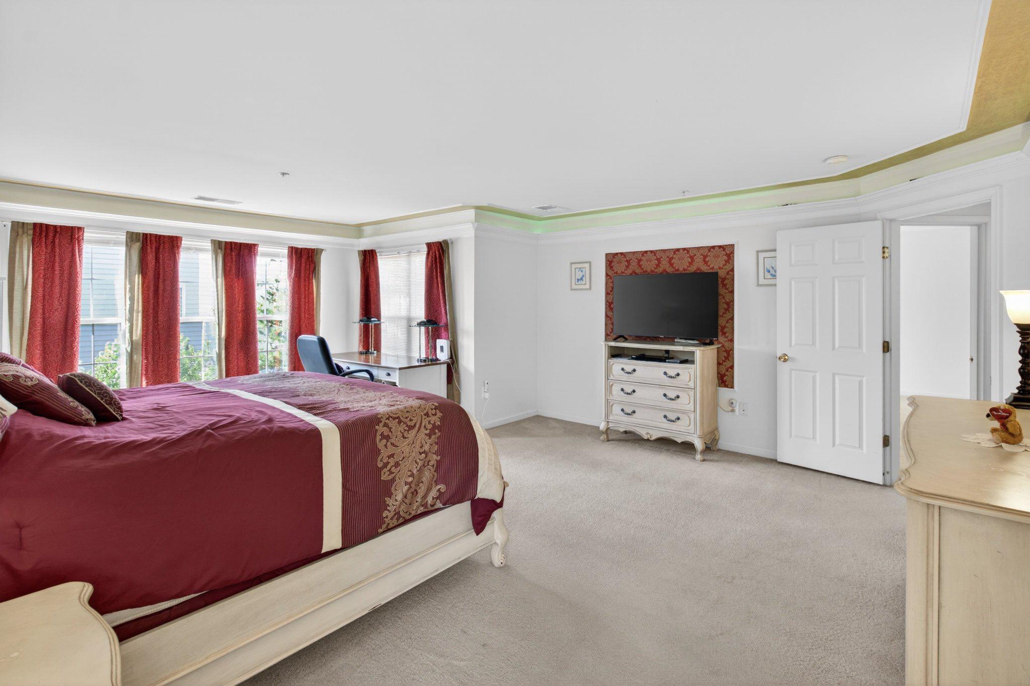 14305 Lightfoot Street Accokeek, MD 20607 - Photo 36 of 66 a spacious bedroom with a bed and a flat screen tv