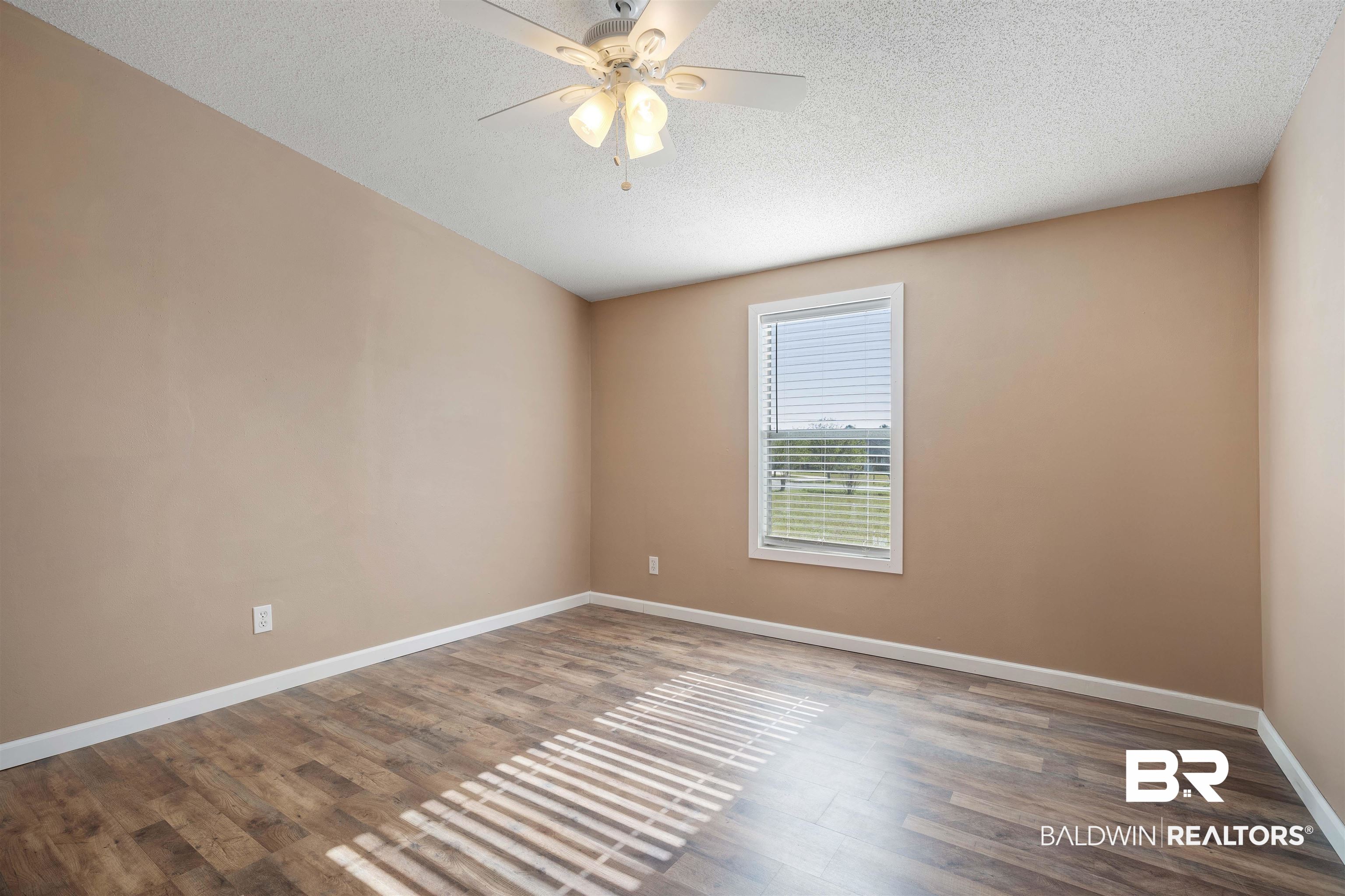 9011 Wilmer Georgetown Road Wilmer, AL 36587 - Photo 19 of 34 Empty room featuring baseboards, wood finished floors, ceiling fan, and a textured ceiling