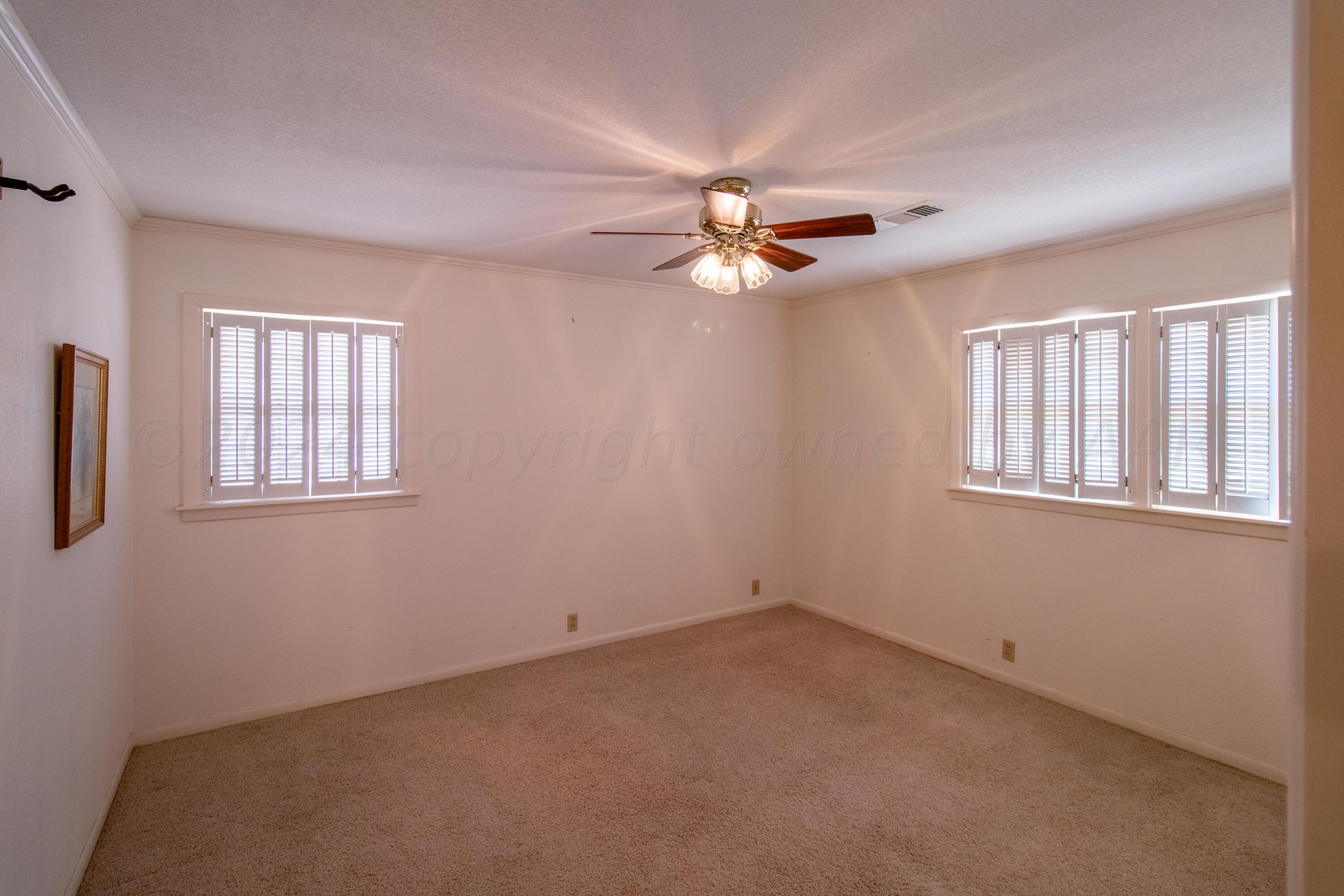 6114 Gainsborough Road Amarillo, TX 79106 - Photo 11 of 20 an empty room with windows and chandelier fan