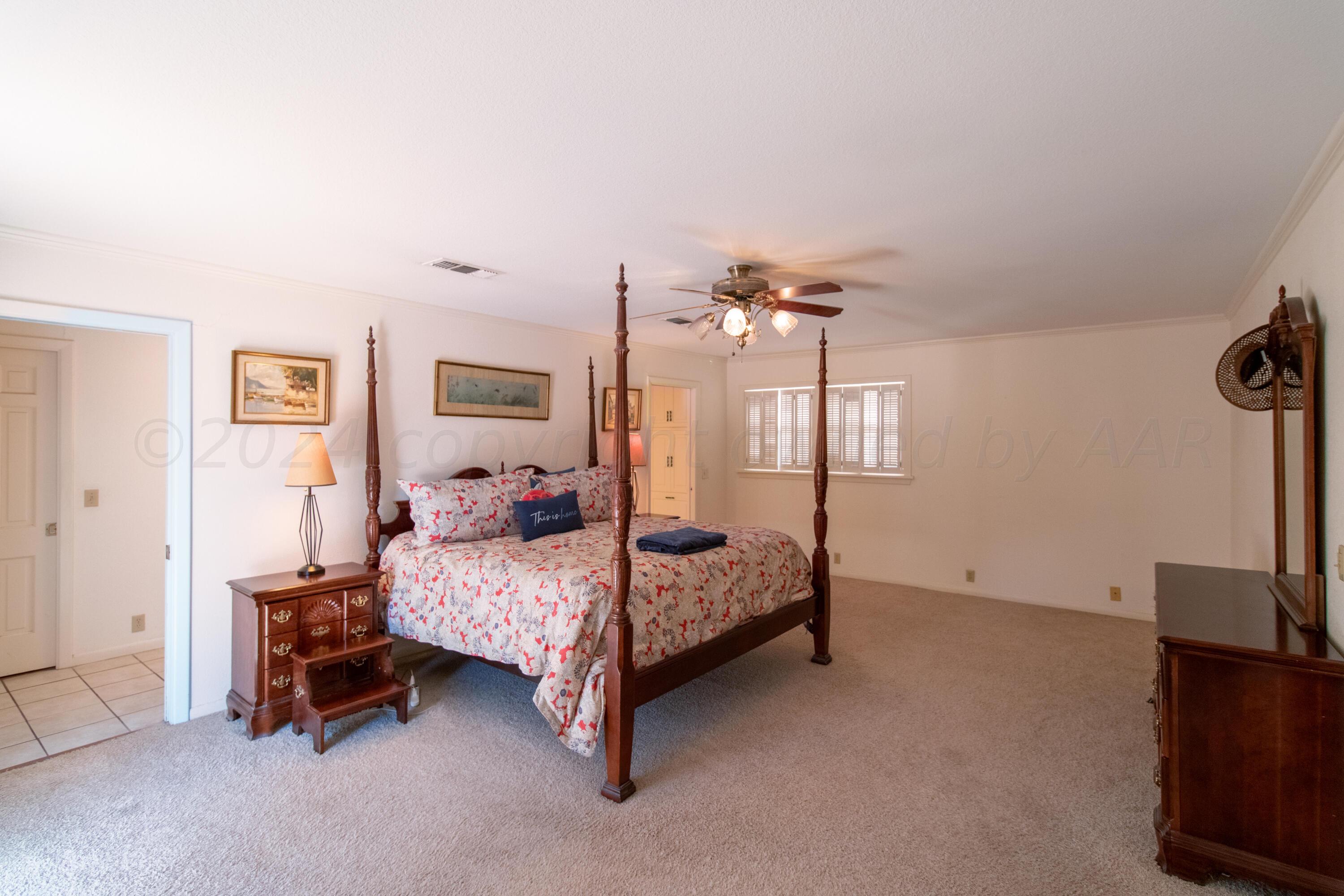 6114 Gainsborough Road Amarillo, TX 79106 - Photo 9 of 20 a bedroom with a bed and a chandelier