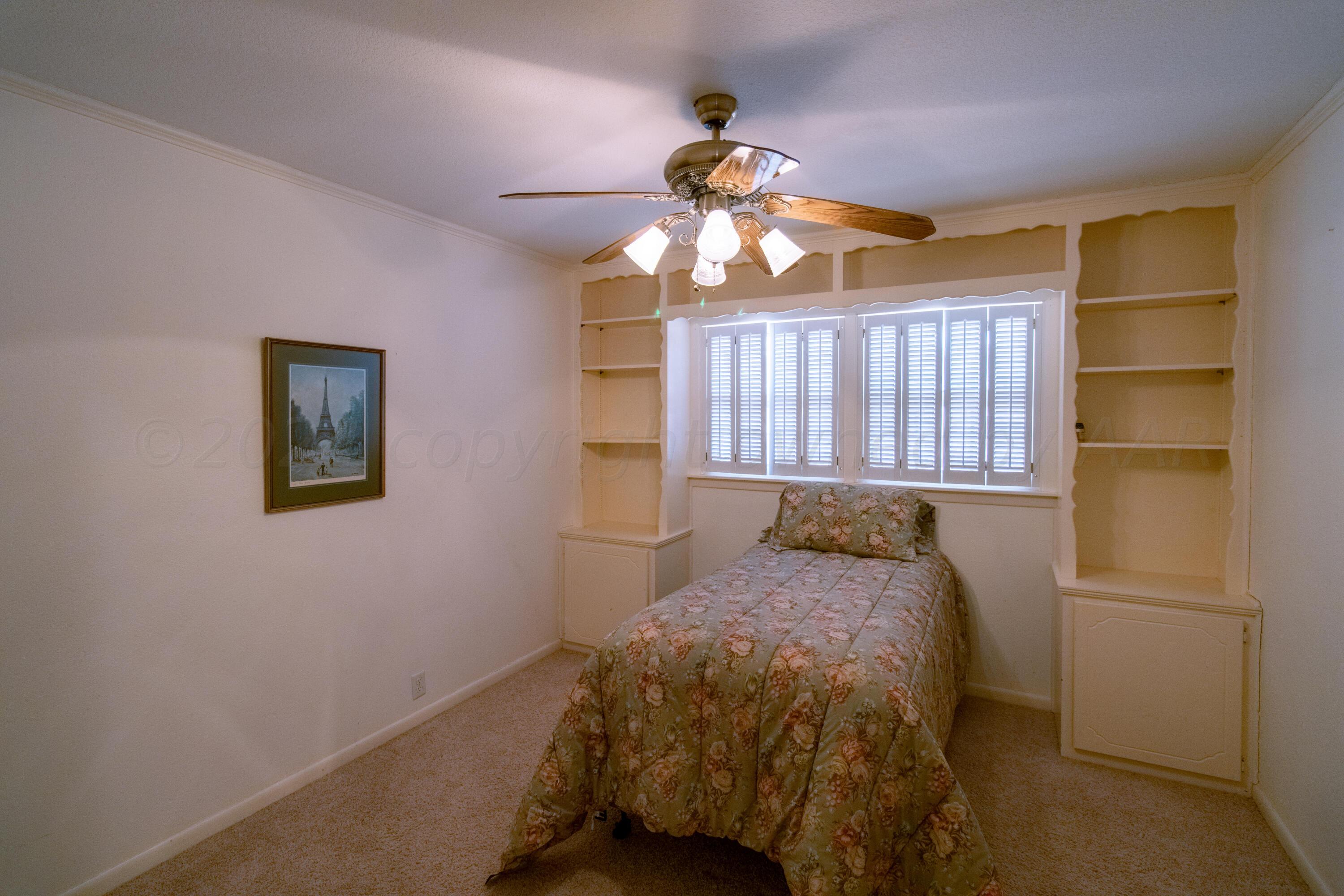 6114 Gainsborough Road Amarillo, TX 79106 - Photo 10 of 20 a bedroom with a bed and a chandelier