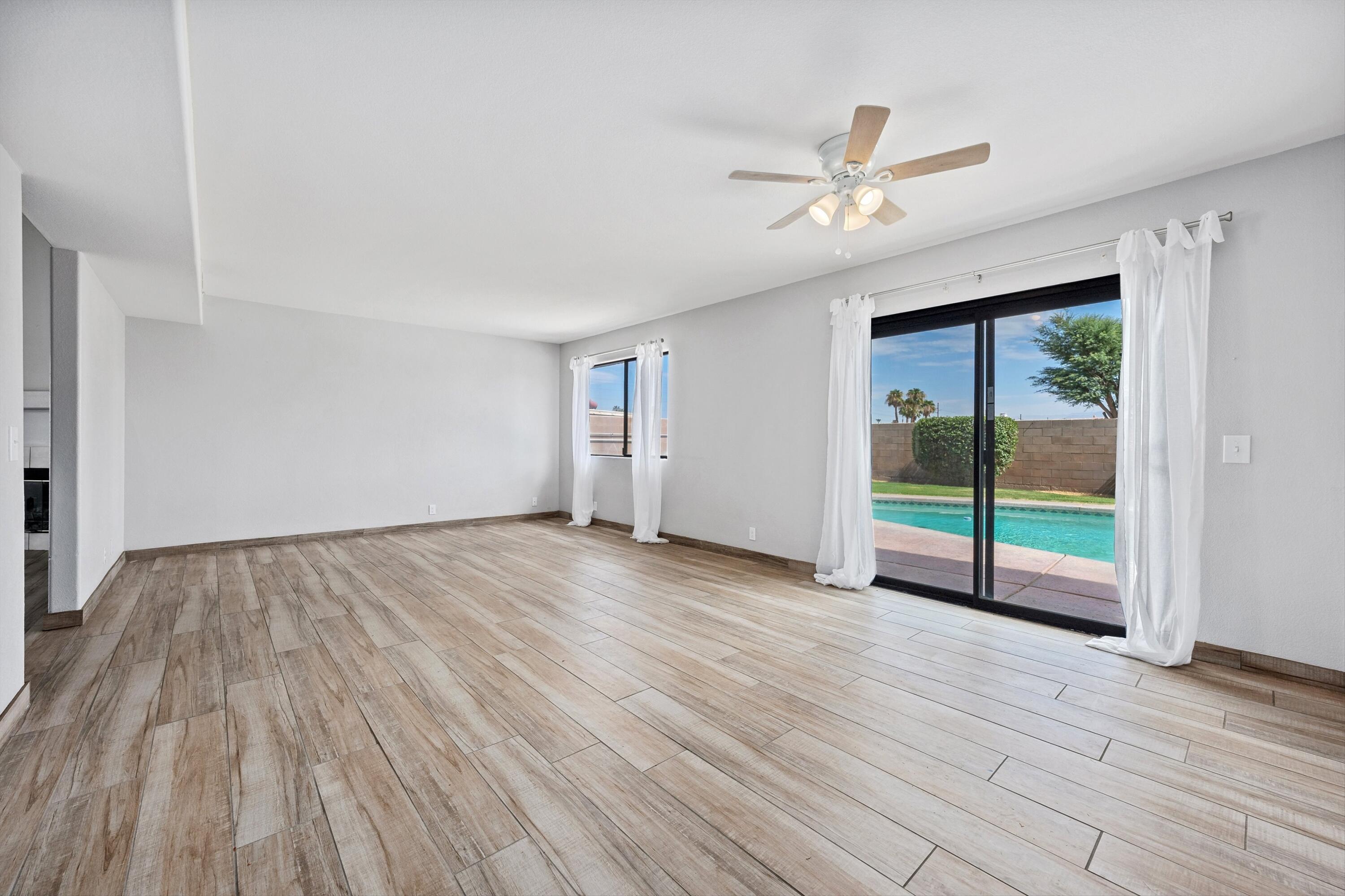 81064 Jessica Way Indio, CA 92201 - Photo 13 of 34 a view of an empty room with a window and wooden floor