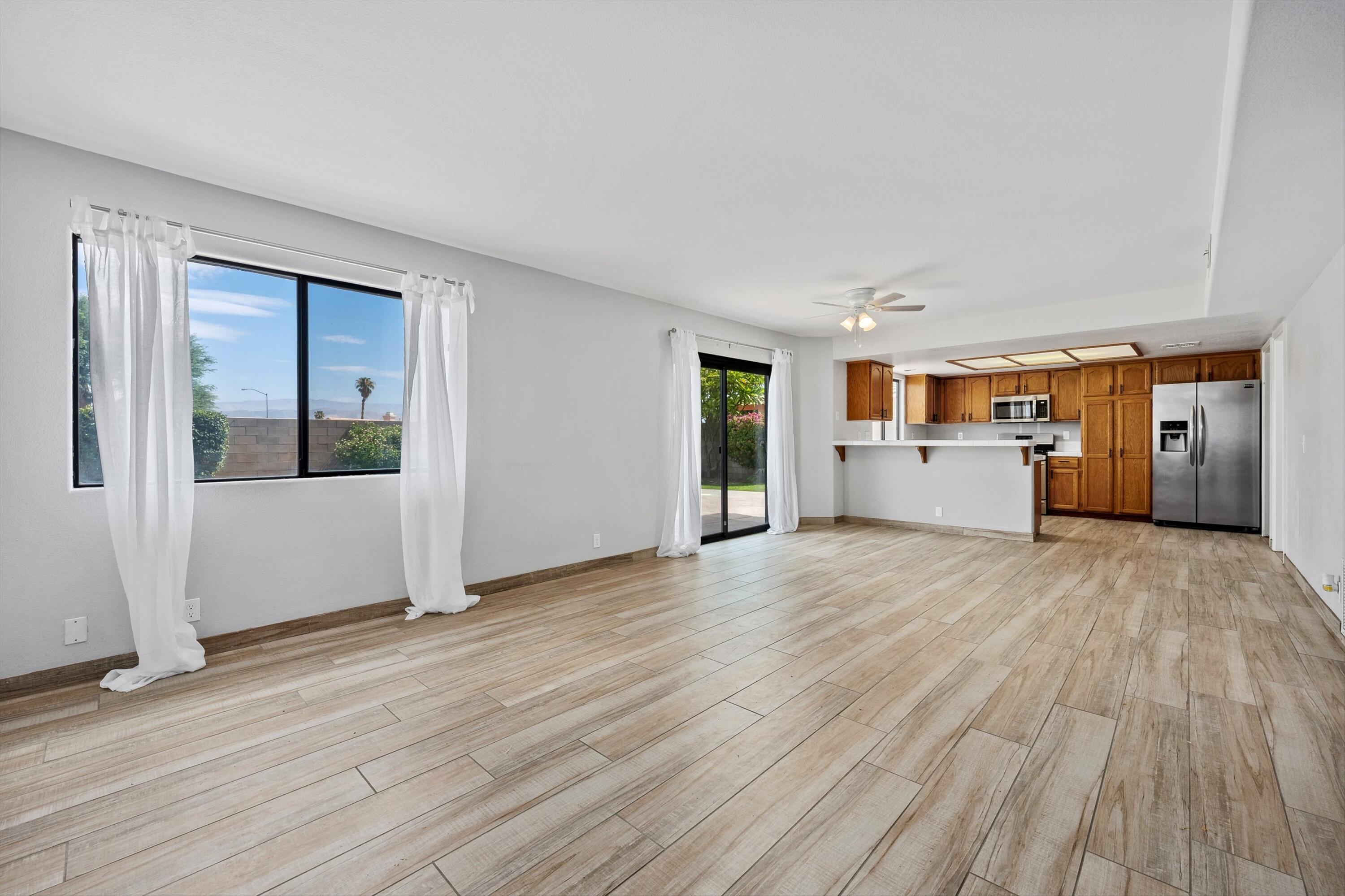 81064 Jessica Way Indio, CA 92201 - Photo 15 of 34 a view of empty room with wooden floor and kitchen