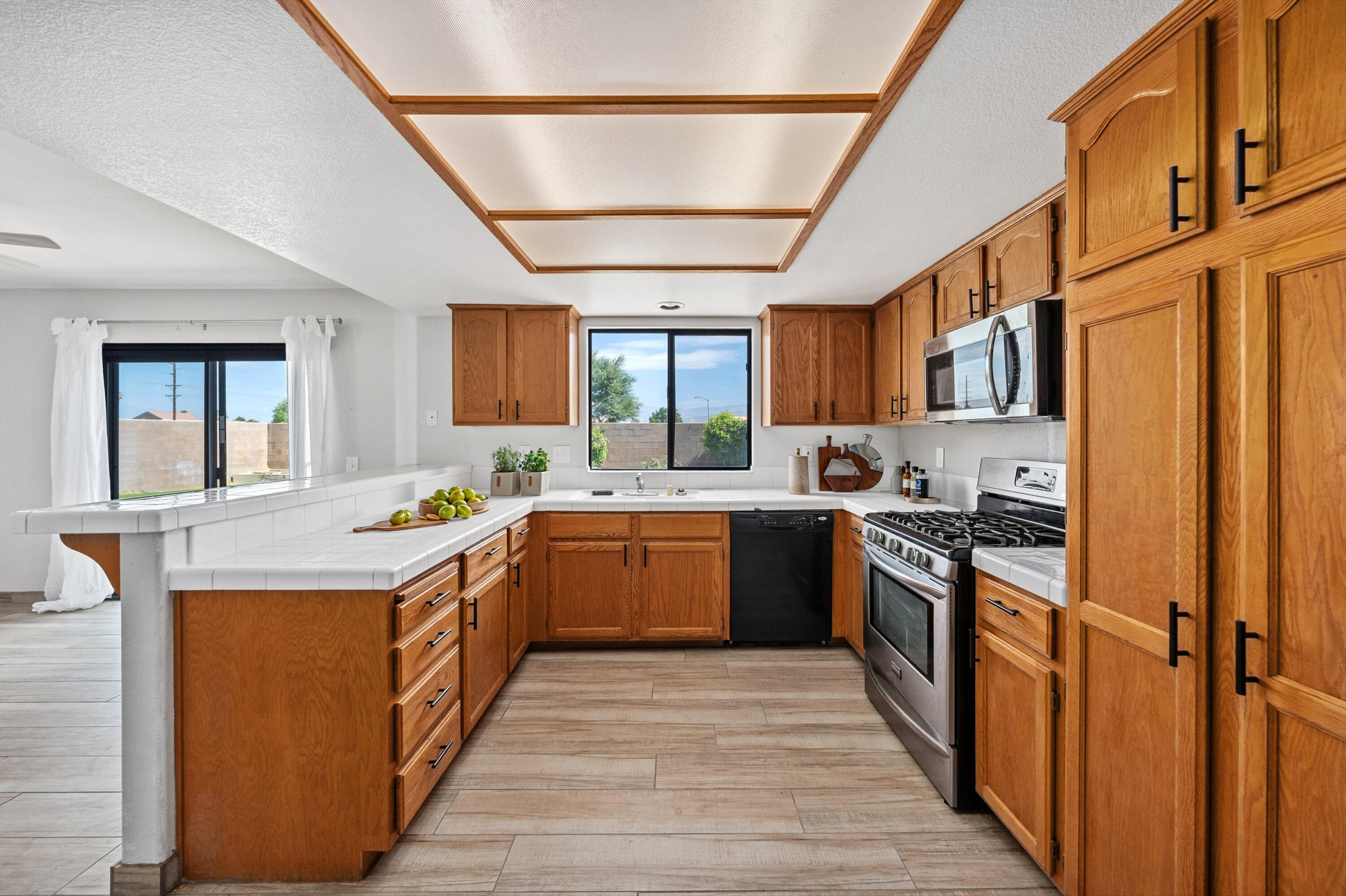 81064 Jessica Way Indio, CA 92201 - Photo 21 of 34 a kitchen with stainless steel appliances granite countertop a stove a sink dishwasher a refrigerator and a oven with wooden floor