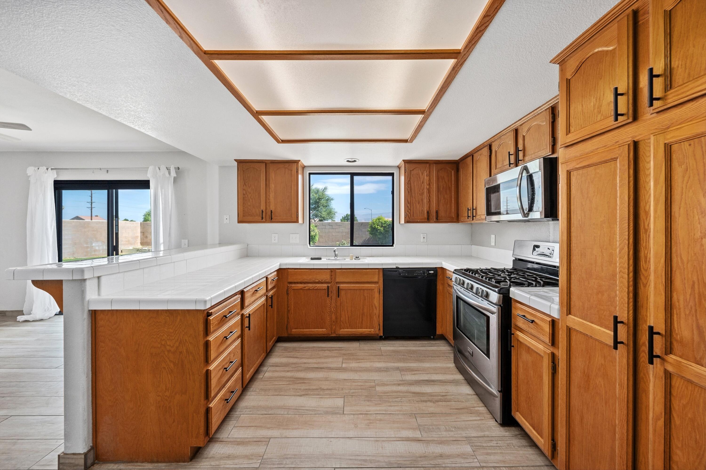 81064 Jessica Way Indio, CA 92201 - Photo 22 of 34 a kitchen with stainless steel appliances granite countertop a stove a sink dishwasher and a refrigerator