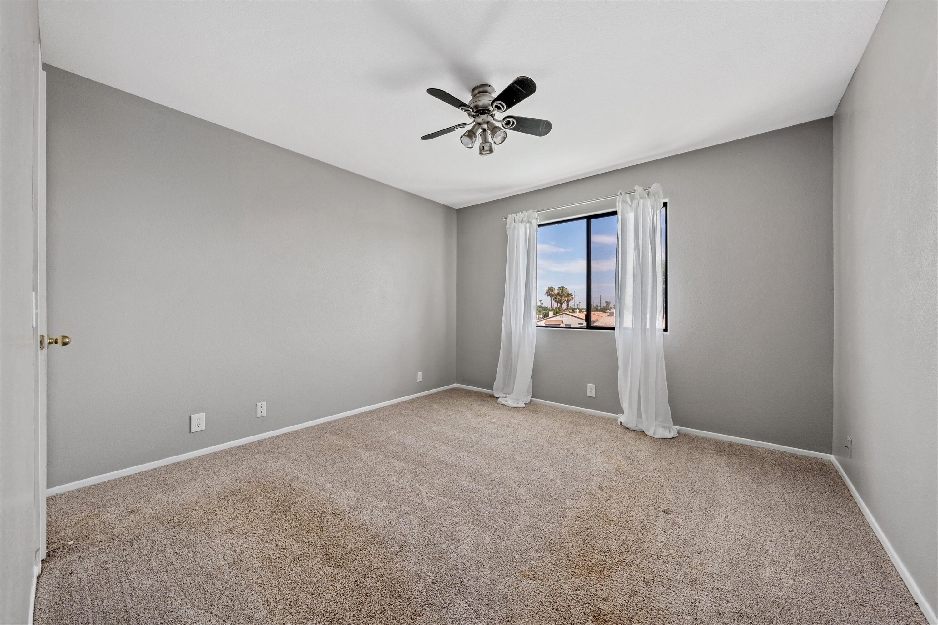 81064 Jessica Way Indio, CA 92201 - Photo 32 of 34 an empty room that has a window and a ceiling fan