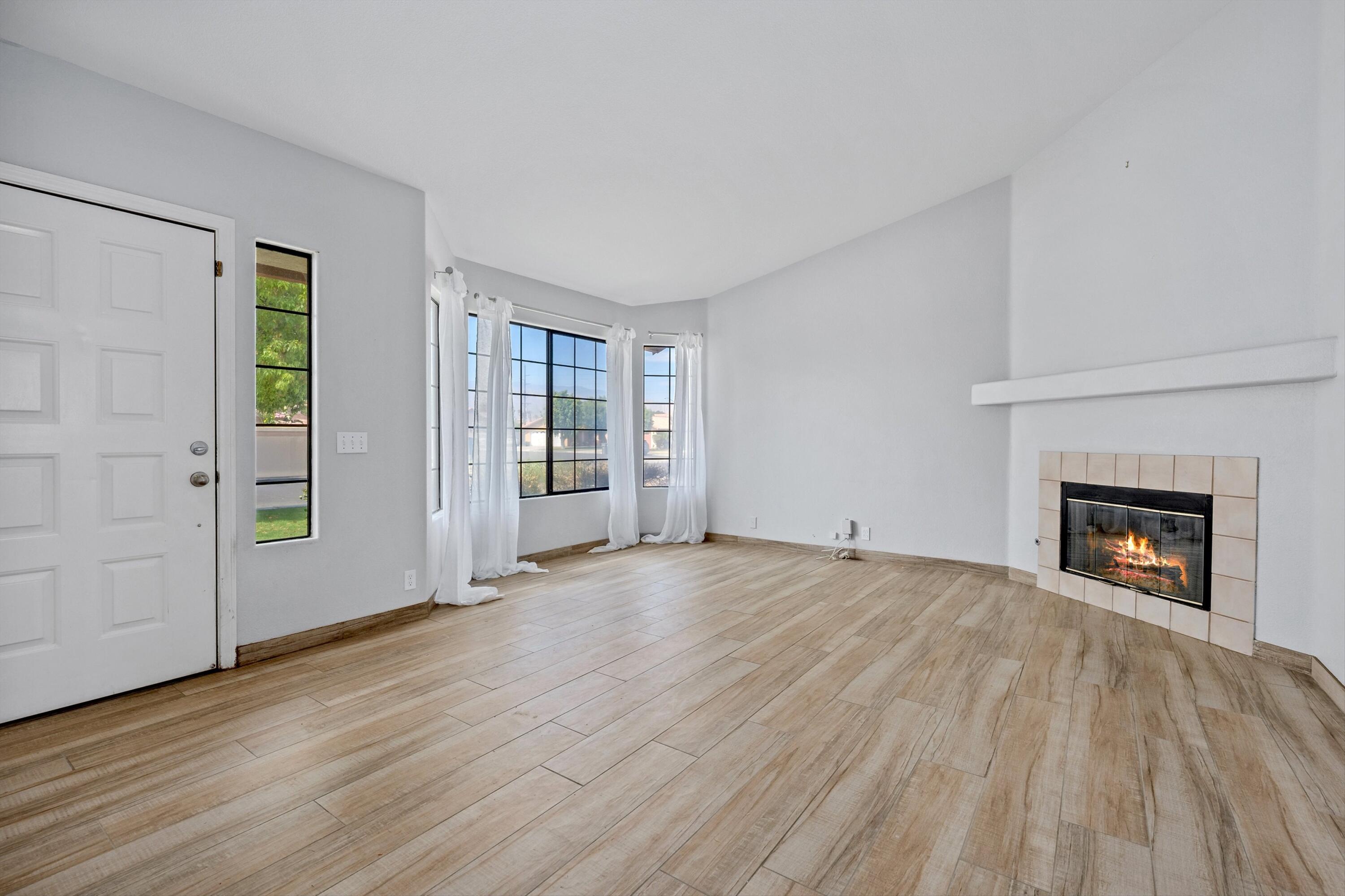 81064 Jessica Way Indio, CA 92201 - Photo 6 of 34 wooden floor fireplace and windows in an empty room