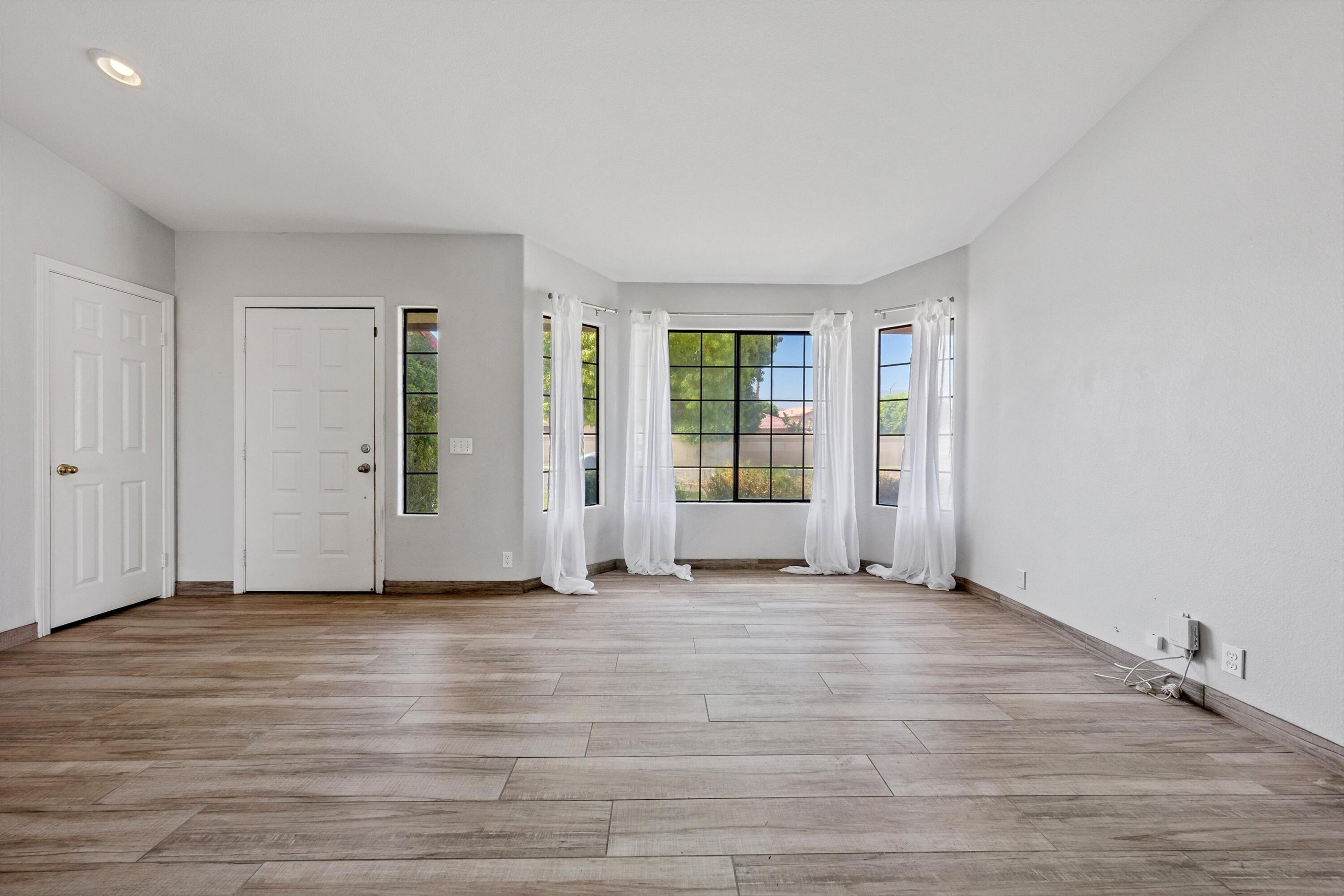 81064 Jessica Way Indio, CA 92201 - Photo 10 of 34 a view of an empty room with wooden floor and a window