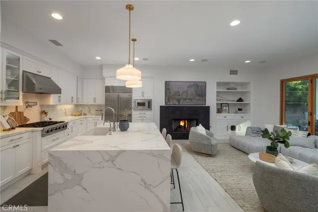 a living room with furniture a fireplace and a kitchen view