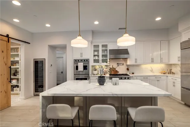 a kitchen with a dining table chairs stainless steel appliances and cabinets