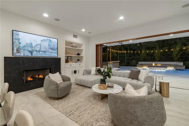 a living room with fireplace furniture and a large window