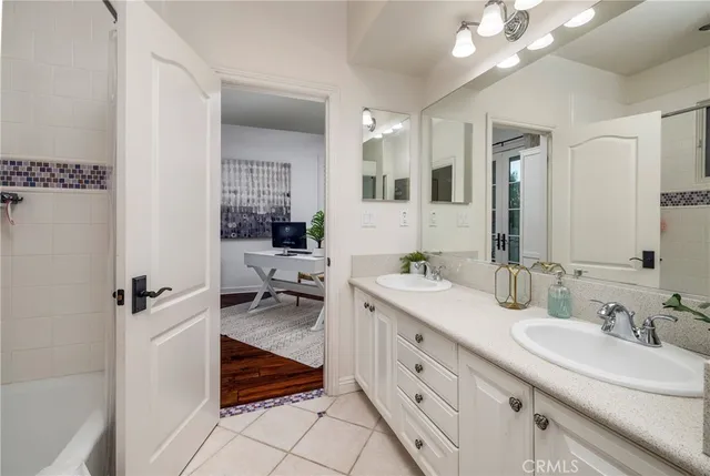 a bathroom with a double vanity sink a mirror and a shower
